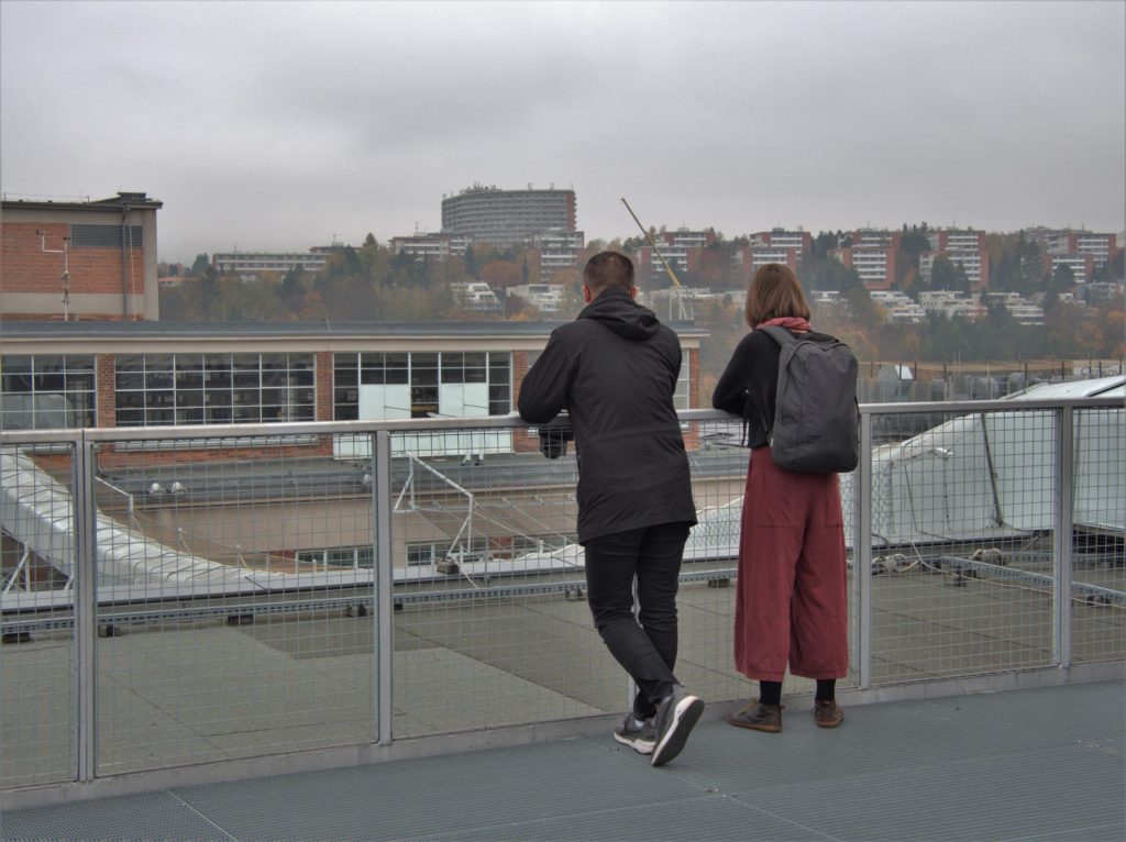 deux étudiants de dos regardant un site industriel

